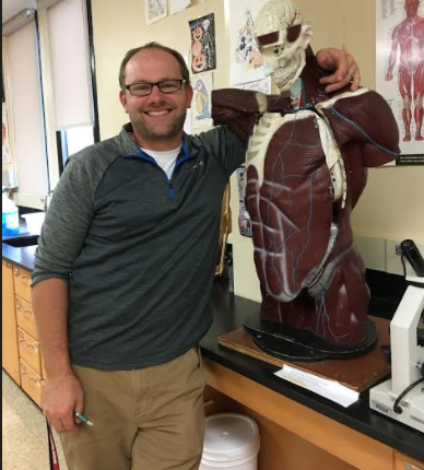 Jesse Schettle with a biology prop, which he sometimes uses in class