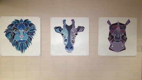 Lion, giraffe and rhino canvases, created by senior Jenna Beyer, greet students outside the cafeteria.