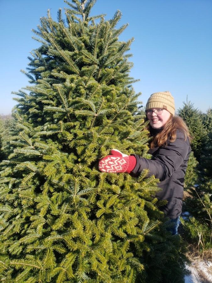 A picture of me hugging my familys Christmas Tree this year.