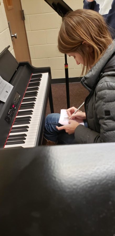 Ms. Amy Westcott makes note of a students vocal range while auditioning her for Advanced Chamber Choir.