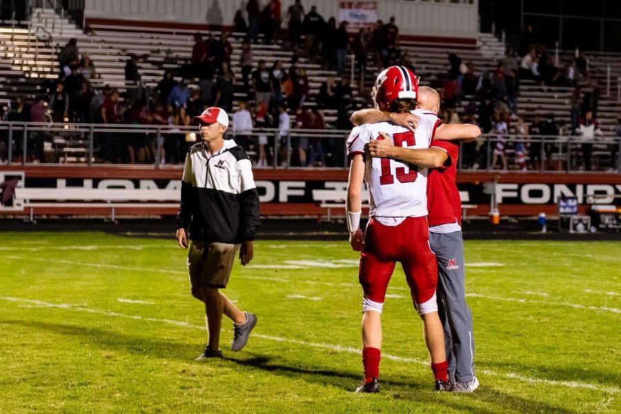 Matt Jung (15) hugs his father, Coach Steve Jung, after 21-7 win over Fond Du Lac.