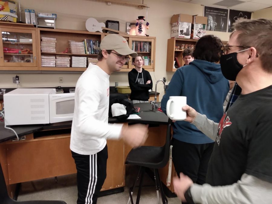 Hans Patel (senior) uses his microwave-backpack to heat up a cup of coffee for physics teacher Mr. Hertting.  