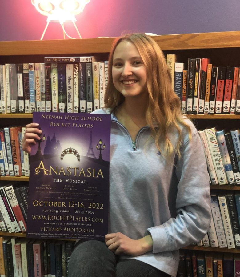 Maddie Van Zeeland who performs the lead role of Anastasia holding the performance poster.