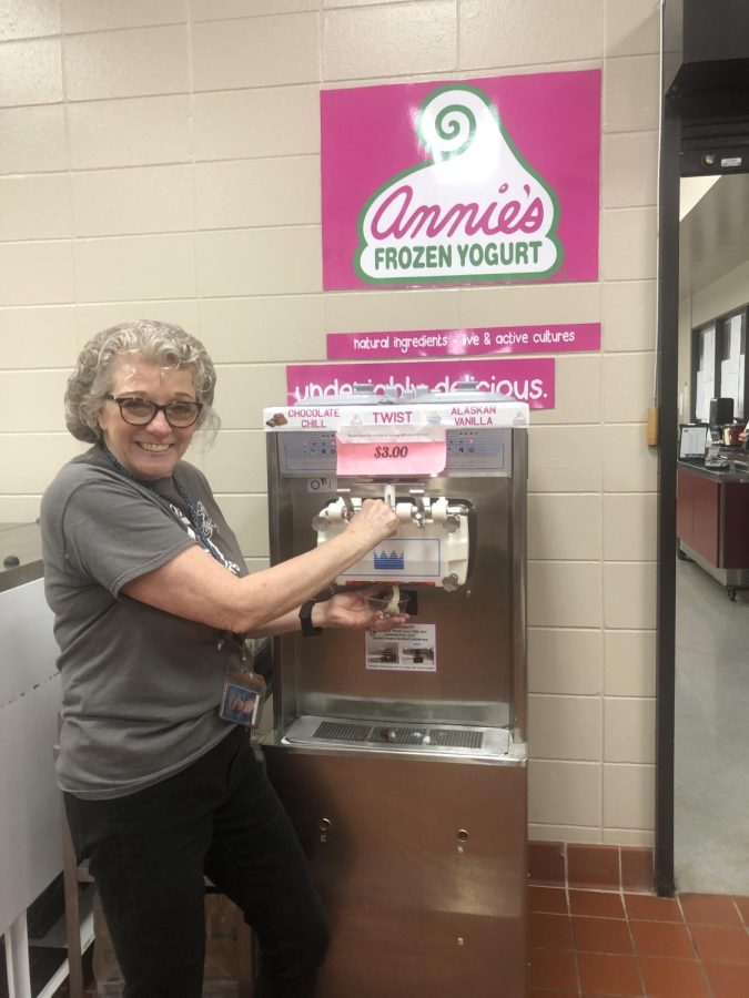 Lunch lady demonstrating self serve Annies Frozen Yogurt machine. 